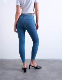 Model wearing Hourglass Joni high rise super skinny jean in mid blue