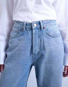 Model wearing Mid rise loose fit straight jean in bleach