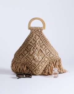 Model wearing Hugo weave tassel straw bag in natural