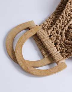 Model wearing Hugo weave tassel straw bag in natural