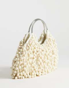 Model wearing Hunter bead grab bag with metal handle in ivory