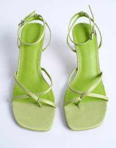 Model wearing Ila toe loop mid heel sandal in green