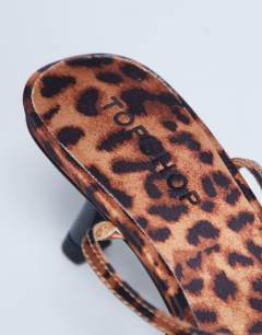 Model wearing Ila toe loop mid heel sandal in leopard print