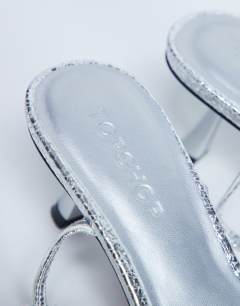 Model wearing Ila toe loop mid heel sandal in silver