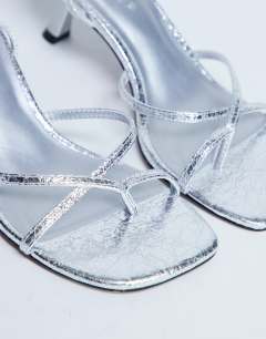 Model wearing Ila toe loop mid heel sandal in silver