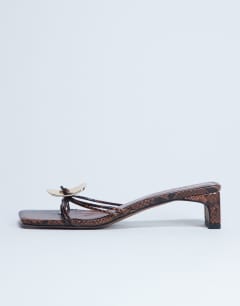 Model wearing Ilaria kitten heeled sandal with metal trim in snake