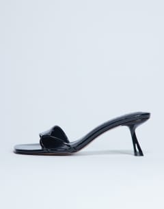 Model wearing Ily patent heeled mule in black