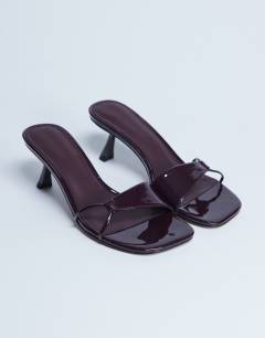 Model wearing Ily patent heeled mule in burgundy