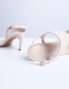 Model wearing Iman toe loop heeled sandal in off white