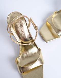 Model wearing Immy cone heel sandal in gold