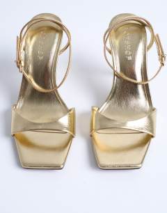 Model wearing Immy cone heel sandal in gold
