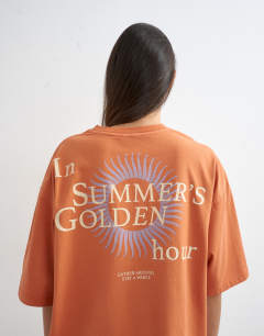 Model wearing In Summers Golden Hours graphic oversized tee in orange