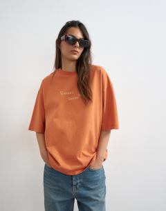 Model wearing In Summers Golden Hours graphic oversized tee in orange