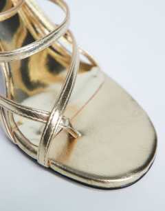 Model wearing Indigo strappy angled heel mule in gold