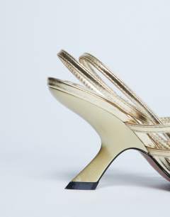 Model wearing Indigo strappy angled heel mule in gold