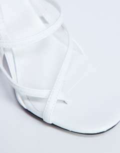 Model wearing Indigo strappy angled heel mule in off white