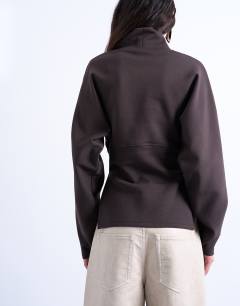 Model wearing Interlock cinch waist long sleeve funnel neck top in chocolate