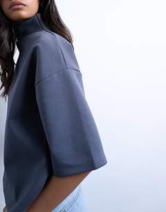 Model wearing Interlock funnel neck top in charcoal grey