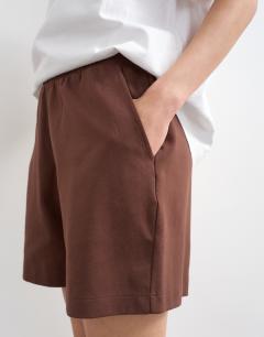 Model wearing Interlock jogger shorts co-ord in chocolate brown