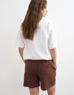 Model wearing Interlock jogger shorts co-ord in chocolate brown