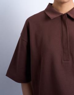 Model wearing Interlock short sleeve polo tee in chocolate brown