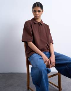 Model wearing Interlock short sleeve polo tee in chocolate brown