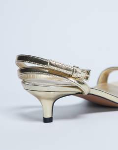 Model wearing Irene barely there mid heeled sandal in gold