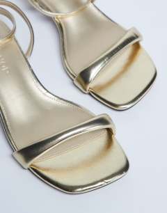 Model wearing Irene barely there mid heeled sandal in gold