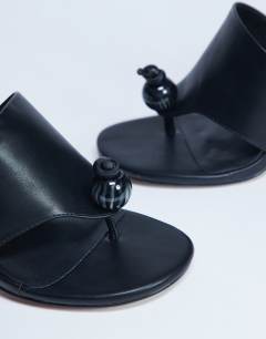 Model wearing Isai beaded toe thong heeled mule in black