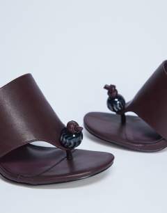 Model wearing Isai beaded toe thong heeled mule in burgundy