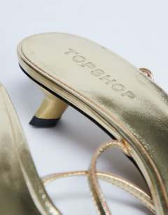 Model wearing Isme strappy kitten heel in gold