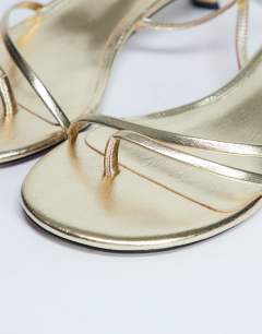 Model wearing Isme strappy kitten heel in gold