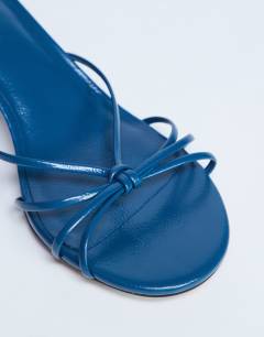 Model wearing Itzel tie up mid heel sandal in teal