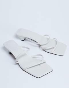 Model wearing Iva strappy kitten heel mule in white