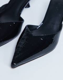 Model wearing Ivette croc patent close toe mule in black