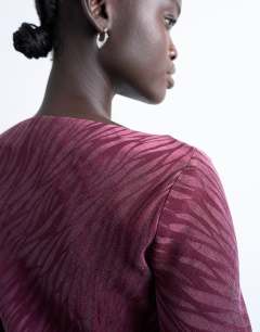 Model wearing Jacquard zebra slash neck long sleeve in burgundy