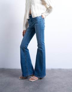 Model wearing Jamie flare high rise jean in mid blue 