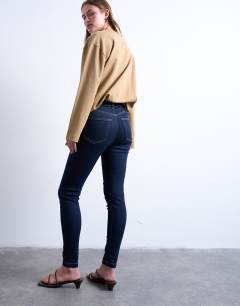 Model wearing Jamie high rise skinny jean in indigo rinse
