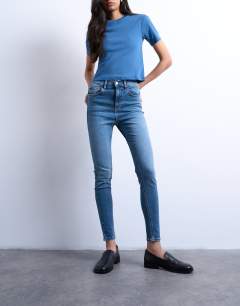 Model wearing Jamie skinny high rise jean in vintage blue