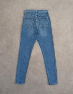 Model wearing Jamie skinny high rise jean in vintage blue