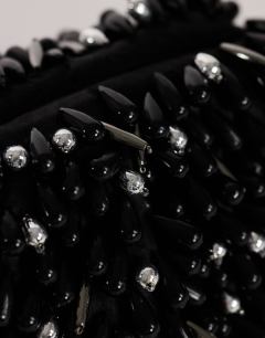 Model wearing Jemma small beaded clutch bag in black and silver
