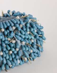 Model wearing Jemma small beaded clutch bag in blue