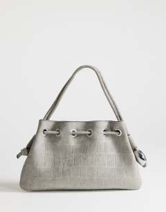 Model wearing Jessie medium hardware grab in grey croc