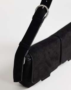 Model wearing Joanie small shoulder bag with front pockets in black suedette