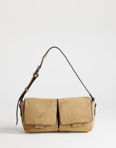 Model wearing Joanie small suedette shoulder bag with front pockets in taupe