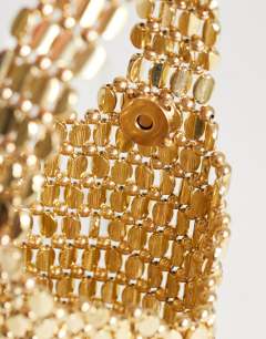 Model wearing Junoe small beaded wristlet grab bag in gold