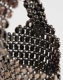 Model wearing Junoe small beaded wristlet grab bag in pewter