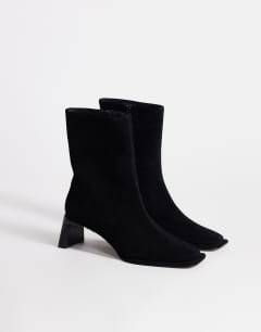 Model wearing Kali real suede heeled ankle boot in black