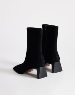 Model wearing Kali real suede heeled ankle boot in black