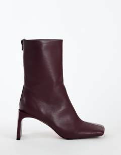 Model wearing Kane angular heeled ankle boot in aubergine